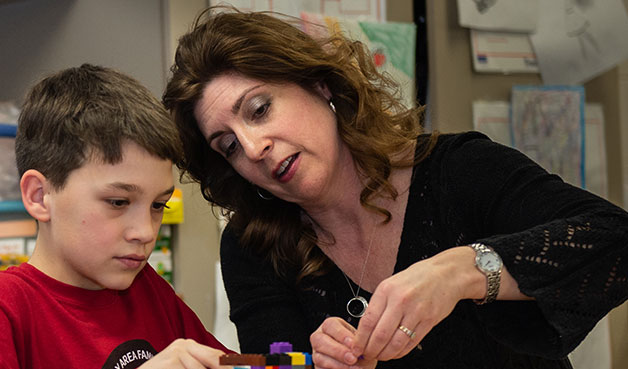 A teacher building Lego's with a student